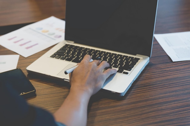 A close-up shot of a person's hands typing on a laptop, with several certifications displayed in the background. The image highlights the acquisition of new skills and credentials through career training.